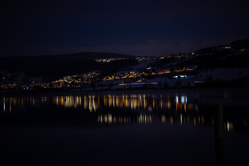 Swiss lake and lights in the middle of the freezing night