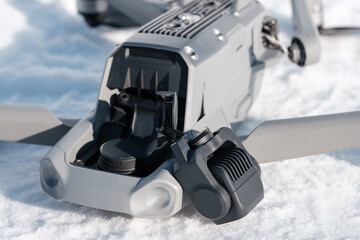 Broken gimbal camera and drone motor arm after crash on snow outdoor closeup