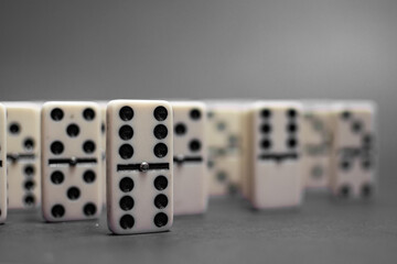 Old fashioned dirty domino stands on a solid backround
