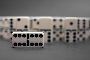 Old fashioned dirty domino stands on a solid backround
