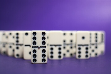 Old fashioned dirty domino stands on a solid backround
