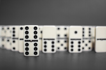 Old fashioned dirty domino stands on a solid backround
