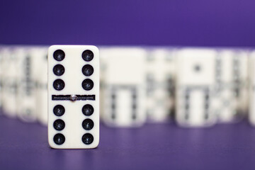 Old fashioned dirty domino stands on a solid backround

