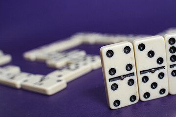 Old fashioned dirty domino stands on a solid backround
