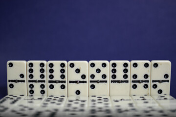 Old fashioned dirty domino stands on a solid backround
