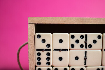 Old fashioned dirty domino on a box with pink solid backround
