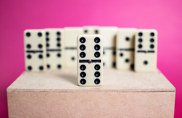 Old fashioned dirty domino on a box with pink solid backround
