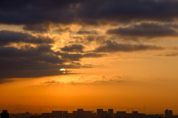 神戸の高台からの日の出。厚い雲から顔を出す、太陽があたりをオレンジ色に染める。天使の梯子が現れた。