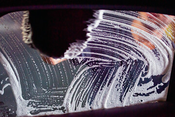 soapy sponge on glass and foam with bubbles