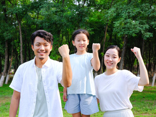 Happy family of three playing in the park
