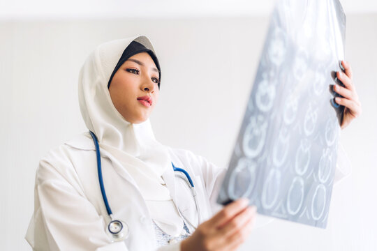 Muslim asian woman doctor looking at x-ray photo.healthcare and medicine