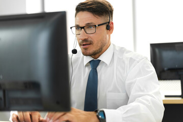 Happy call center smiling businessman operator customer support consult phone services agen working with wireless headset microphone and computer at call center office