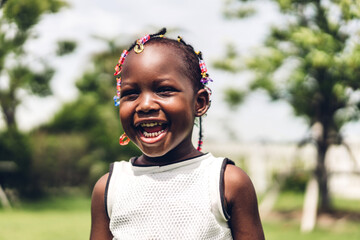 Portrait of happy smiling little child african american girl in park