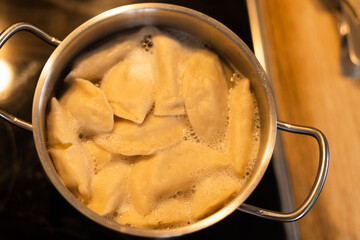 Dumplings are boiled in water close-up, top view