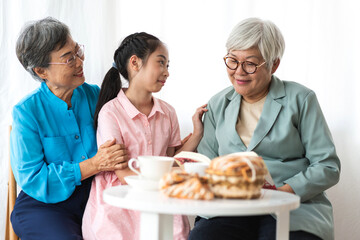 Portrait of happy asian grandmother and little asian cute girl enjoy relax in home.Young girl with their laughing grandparents smiling together.Family and togetherness