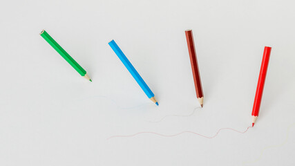 Top view of four colored pencils drawing on a white background.