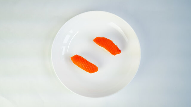 top view, white plate of sushi on a white background, red fish on rice