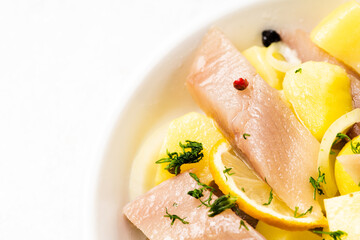 Salted herring with spices and chopped boiled potatoes. Selective focus. Shallow depth of field.