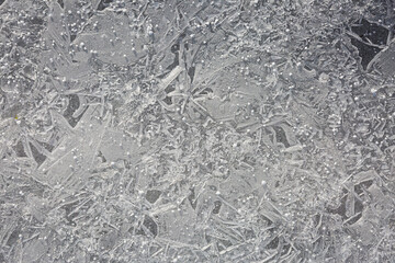 Ice crystals formed by water on the road after melted snow