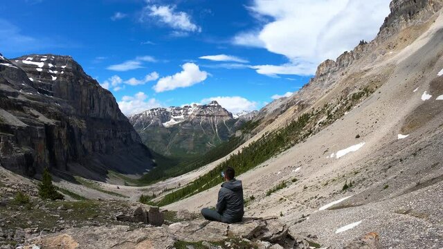 Guy hiker is drinking water from a bottle at Stanley Glacier in Kootenay National Park, Canada - a popular hiking trail in British Columbia
