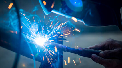 Welding of steel, sparking, not wearing gloves, light colored like fireworks.