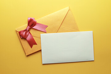 Greeting card and envelope isolated on yellow background. Top view