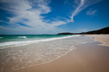 Long beach on Keppel Island, Queensland, Australia. Sun-soaked sand beside the turquoise ocean at the start of the Great Barrier Reef.