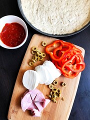 ingredients for homemade pasta on wooden table on brown background.