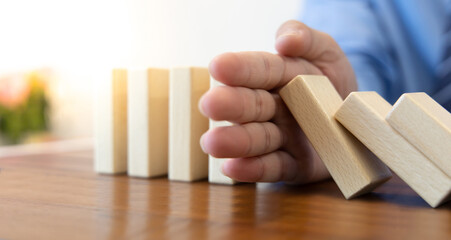 Businesswoman stops hands falling over domino to stop risk continuously, Continuous damage...