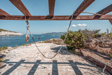 Swing on Bisevo blue cave island near Komiza in Croatia Adriatic sea in summer time