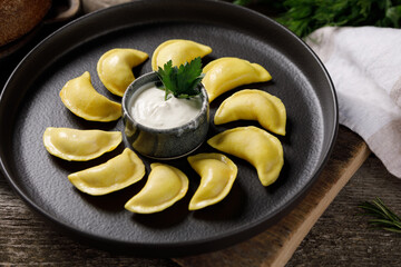 Appetizing traditional Russian dumplings made by hand with delicious filling. Still life on a wooden board. Close-up.