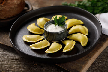 Appetizing traditional Russian dumplings made by hand with delicious filling. Still life on a wooden board. Close-up.