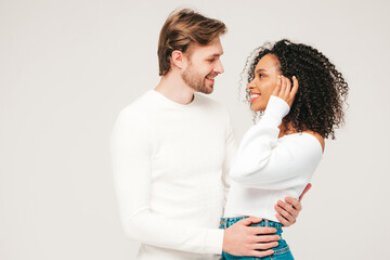 Smiling beautiful woman and her handsome boyfriend. Happy cheerful multiracial family having tender moments on grey background  in studio. Multiethnic models hugging. Embracing each other.Love concept