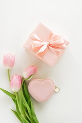 Fototapeta na wymiar Holiday background. pink tulip flowers, pink heart gift box top view on white background. Valentine's da, Birthday, Women's day, Mother's day backdrop. Flat lay.