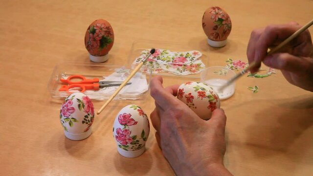 Preparing for Easter Sunday. Decorating eggs with pieces of colored napkins. Technique of simple decoupage. Colorful Easter eggs is festive traditional symbol and gifts. DIY concept