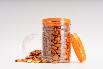 Pine nuts and scattered pine nuts in a transparent box on a pure white background