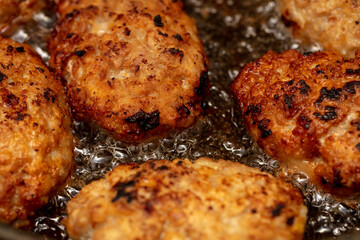 Minced beef cutlets are fried in a pan.