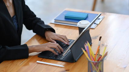 Cropped shot of stylish woman working with computer tablet.