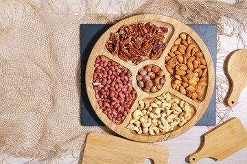 nuts in a wooden bowl. Pecans, Cashews, hazelnuts, almonds, peanuts. Top view with space to copy.