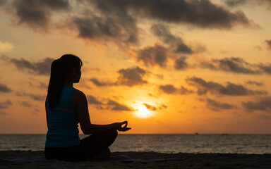 Calm relaxed woman meditating on the beach facing the sun rises.New life for new year concept