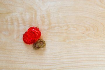 Opened red spiked ball with metal rings background. Korean massage goods to stimulate pain points at Su Jok gym, top view with copy space. Medical equipment pressure tools. Reflexology hand healing.