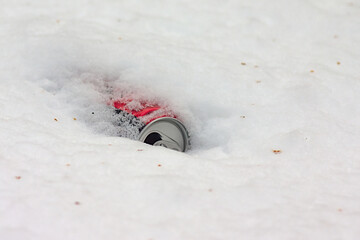 the metal can of the drink is covered with snow