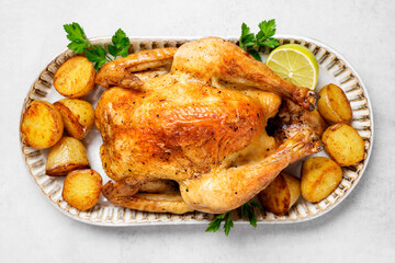 Whole roasted chicken with baked potatoes.