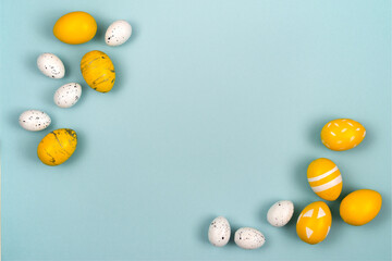 Fototapeta na wymiar Easter eggs in yellow and white on a pastel blue background. Flat lay, top view.