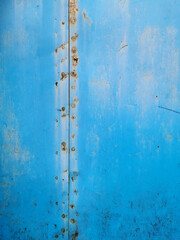 texture of an old metal garage wall exposed to weather and with blue rust paint