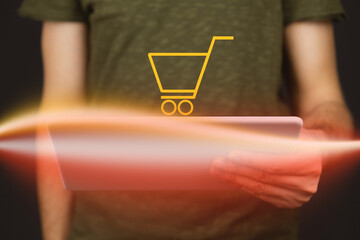 Online einkaufen und bezahlen, Mann hält Tablet in der Hand mit Einkaufswagen Icon