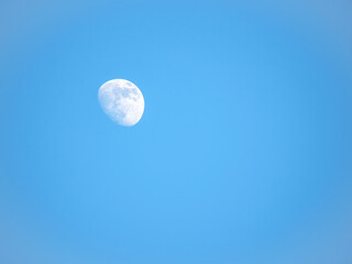 Half moon on clear blue sky.