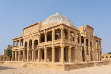 Obraz premium Landscape view of ancient mughal era carved sandstone tomb of Isa Khan Tarkhan II in UNESCO listed Makli necropolis, Thatta, Sindh, Pakistan