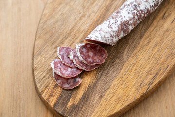 Italian salami sliced on wooden table