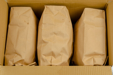 Ecological packaging and tare concept. Open cardboard box with packaged goods in paper bags.